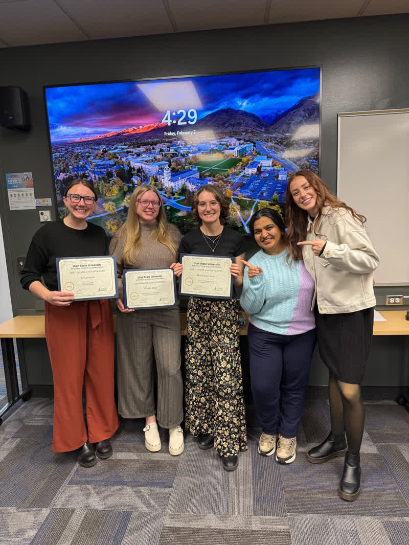 Malin receiving a Utah State University certificate of achievement