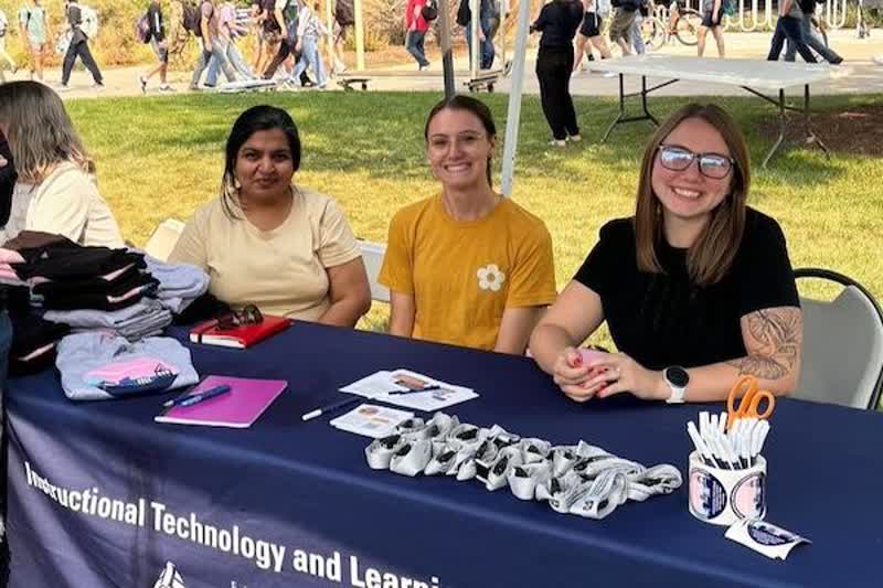 Malin with colleagues at an ITLS campus event table